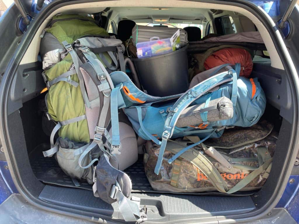 Bil med outdoorgrej til baal og business tur